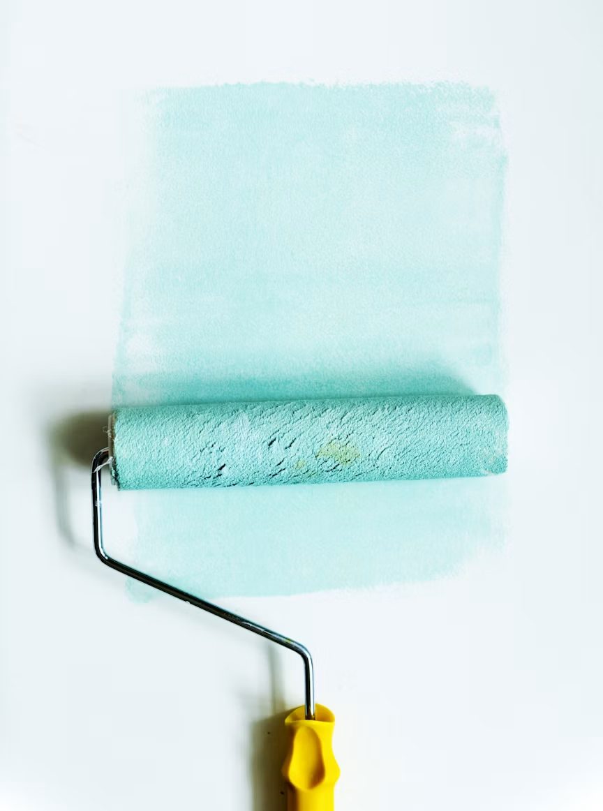 Paint roller applying a fresh colour to a wall