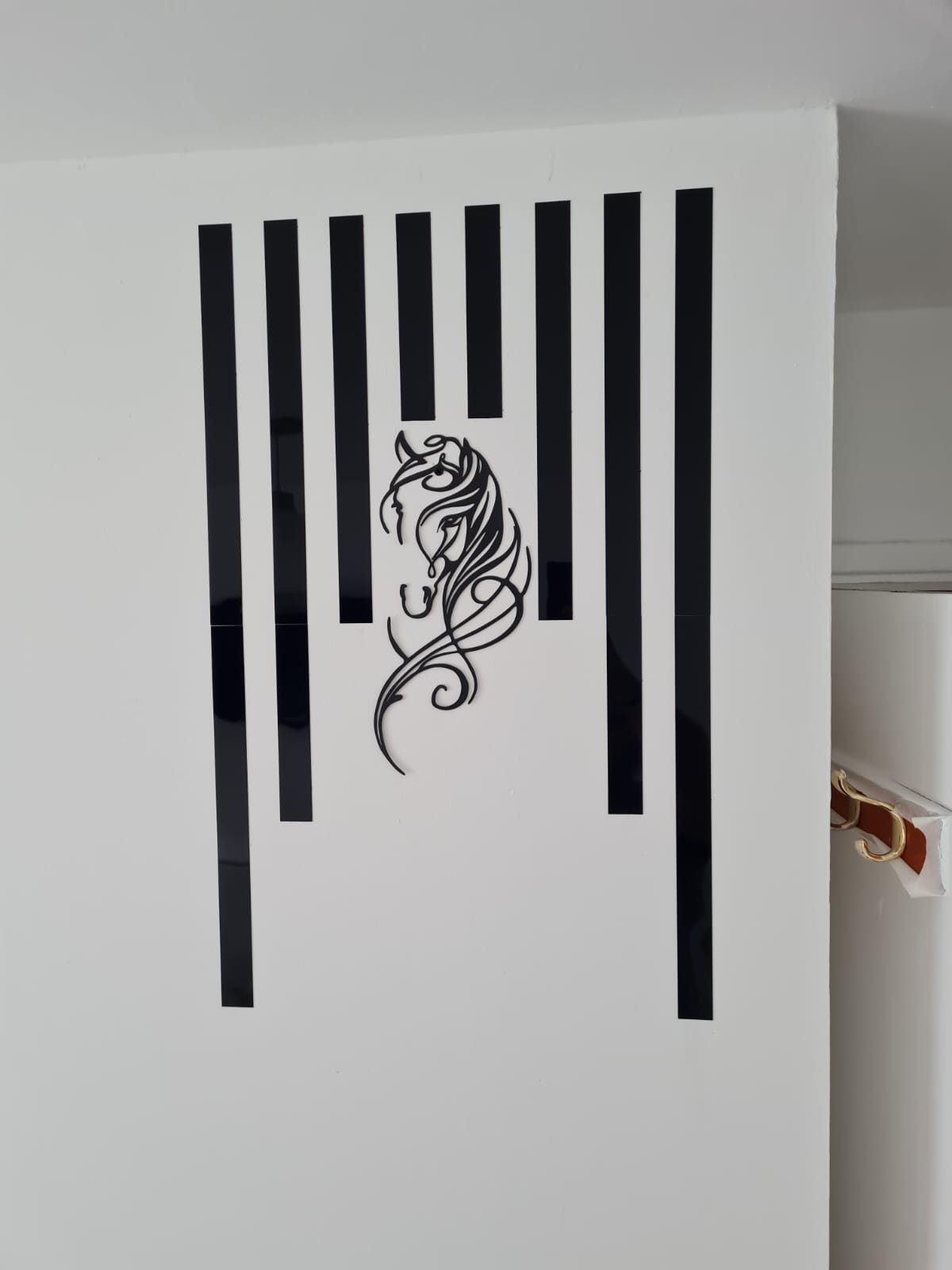 Close-up of striped wall art with horse silhouette