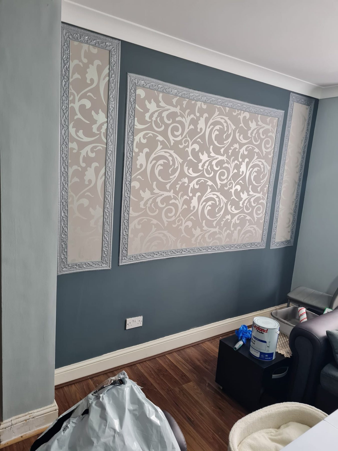 Framed damask wallpaper panels on a dark feature wall